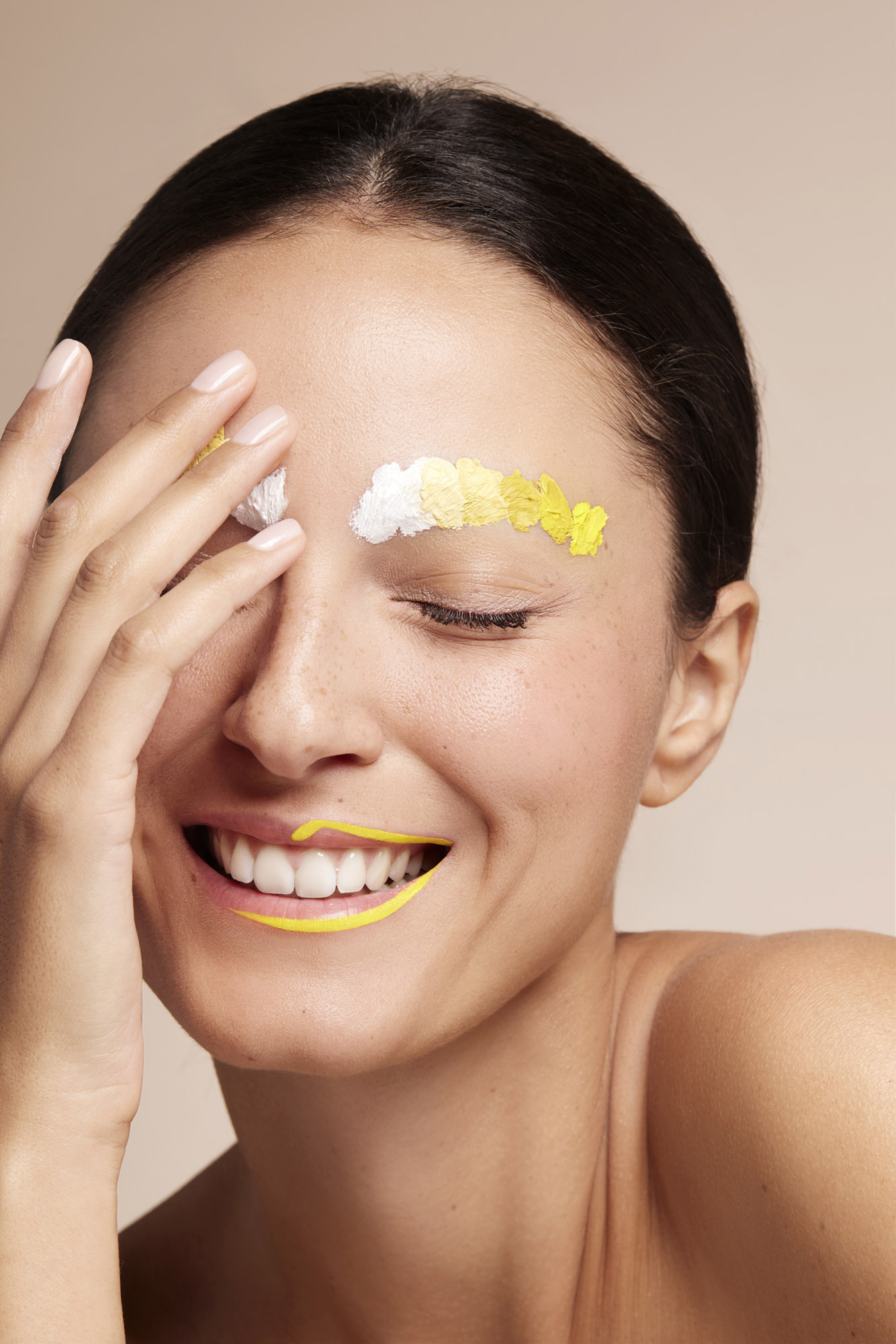 Femme souriante avec un maquillage artistique jaune et blanc, photographiée par le studio Sublimeight